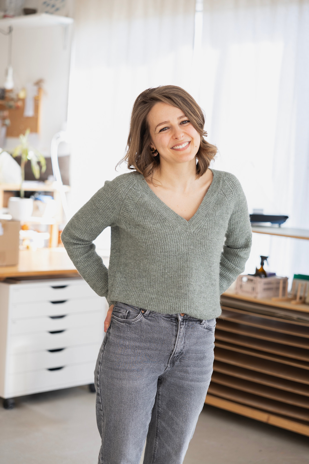 Portrait de Nathalie Wyss, souriante, dans un atelier lumineux